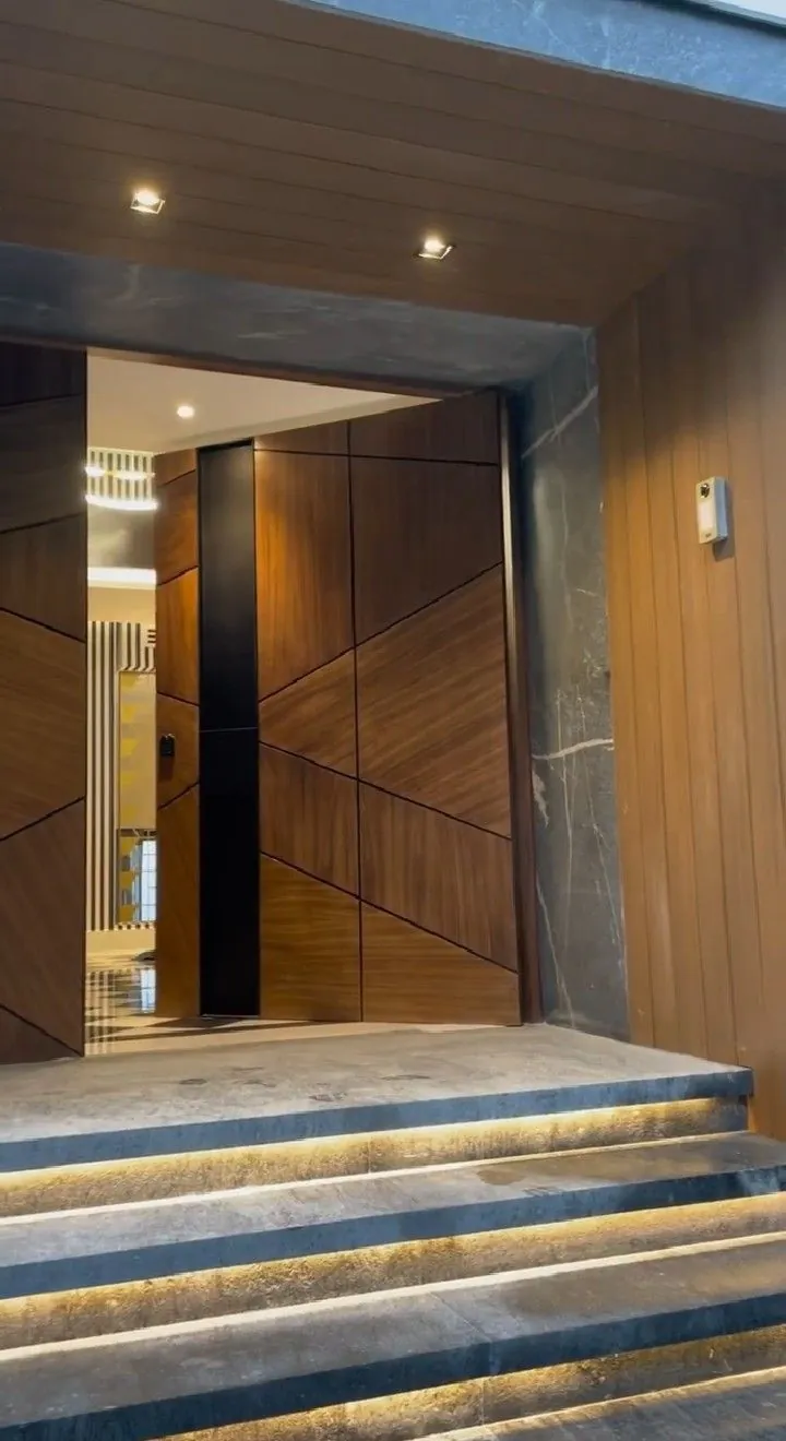 Luxury villa walnut pivot entrance night