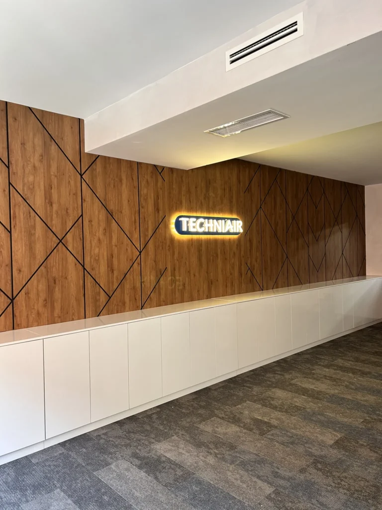 Office reception walnut wood feature wall techniair sign